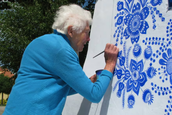 Flores azules sobre muros blancos: la historia de la mujer que convirtió su pueblo en una obra de arte